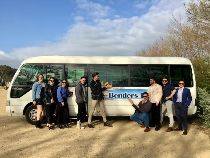 A tour group posing beside the Benders Bus Tours minibus in the Barossa